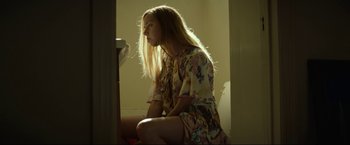 Movie still from “Ingrid Goes West” (2017), directed by Matt Spicer – A woman sitting on a toilet in a room; Medium shot, Low angle
