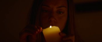 Movie still from “Ingrid Goes West” (2017), directed by Matt Spicer – A woman holding a lit candle in front of her face; Close Up shot, Low angle