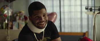 Movie still from “Ingrid Goes West” (2017), directed by Matt Spicer – A man wearing a neck brace sitting in a room; Close Up shot, Over the shoulder angle