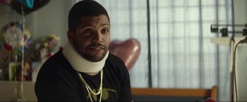 Movie still from “Ingrid Goes West” (2017), directed by Matt Spicer – A man wearing a neck brace sitting in front of a window; Close Up shot, Over the shoulder angle