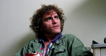 Movie still from “Inherent Vice” (2014), directed by Paul Thomas Anderson – A person with curly hair and a beard; Close Up shot, Low angle