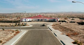 Movie still from “Inherent Vice” (2014), directed by Paul Thomas Anderson – An empty street with a red bridge in the background; Extreme Wide shot, High angle