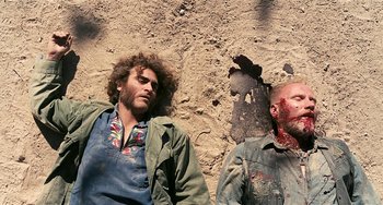 Movie still from “Inherent Vice” (2014), directed by Paul Thomas Anderson – Two men laying on the ground with blood on their heads; Medium shot, Overhead angle