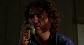 Movie still from “Inherent Vice” (2014), directed by Paul Thomas Anderson – A person talking on a phone; Close Up shot, Low angle