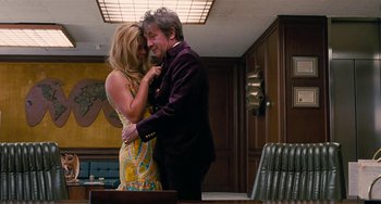 Movie still from “Inherent Vice” (2014), directed by Paul Thomas Anderson – A man and a woman hugging in a room; Medium shot, Over the shoulder angle