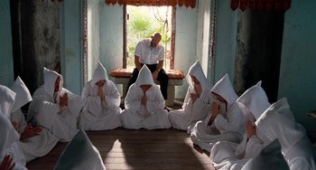 Movie still from “Inherent Vice” (2014), directed by Paul Thomas Anderson – A group of men in white robes sitting in front of a window; Wide shot, High angle