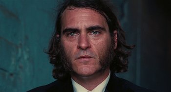 Movie still from “Inherent Vice” (2014), directed by Paul Thomas Anderson – A person wearing a suit and tie; Close Up shot, Low angle