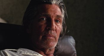 Movie still from “Inherent Vice” (2014), directed by Paul Thomas Anderson – An older man with long gray hair stares into the camera; Close Up shot, Low angle