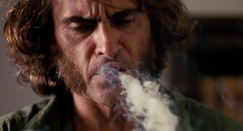 Movie still from “Inherent Vice” (2014), directed by Paul Thomas Anderson – A person smoking a cigarette; Close Up shot, Low angle