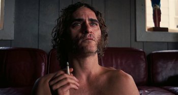 Movie still from “Inherent Vice” (2014), directed by Paul Thomas Anderson – A man with long hair is brushing his teeth; Close Up shot, Low angle