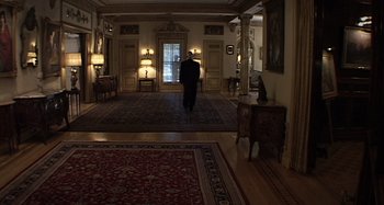 Movie still from “Inland Empire” (2006), directed by David Lynch – A man in a suit walks through a hallway; Extreme Wide shot, High angle