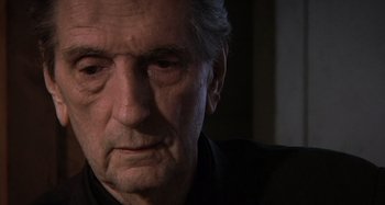 Movie still from “Inland Empire” (2006), directed by David Lynch – An older man with grey hair looking sad; Close Up shot, Low angle