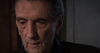 Movie still from “Inland Empire” (2006), directed by David Lynch – An older man looking down at his face; Close Up shot, Low angle
