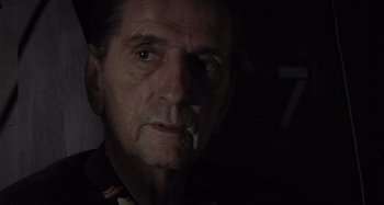Movie still from “Inland Empire” (2006), directed by David Lynch – An older man with a cigarette in his mouth; Close Up shot, Low angle