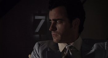 Movie still from “Inland Empire” (2006), directed by David Lynch – A person wearing a suit and tie; Close Up shot, Low angle