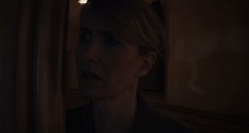 Movie still from “Inland Empire” (2006), directed by David Lynch – A woman is looking into the distance in a dark room; Close Up shot, Over the shoulder angle