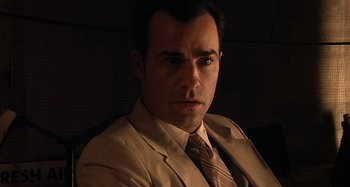 Movie still from “Inland Empire” (2006), directed by David Lynch – A person wearing a suit and tie; Close Up shot, Low angle