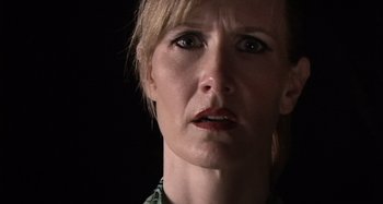 Movie still from “Inland Empire” (2006), directed by David Lynch – A woman's face in a dark room; Close Up shot, Low angle