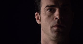 Movie still from “Inland Empire” (2006), directed by David Lynch – A man's face with a black background; Extreme Close Up shot, Low angle