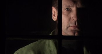 Movie still from “Inland Empire” (2006), directed by David Lynch – A person looking through a window; Close Up shot, Low angle