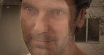 Movie still from “Inland Empire” (2006), directed by David Lynch – A man's face in a mirror; Extreme Close Up shot, Low angle