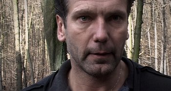 Movie still from “Inland Empire” (2006), directed by David Lynch – A person wearing a black shirt; Close Up shot, Low angle