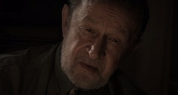 Movie still from “Inland Empire” (2006), directed by David Lynch – An old man with a beard and a tie; Close Up shot, Over the shoulder angle