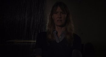 Movie still from “Inland Empire” (2006), directed by David Lynch – A woman standing in the dark under a rain shower; Close Up shot, Low angle