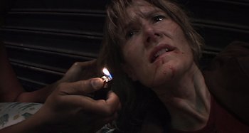 Movie still from “Inland Empire” (2006), directed by David Lynch – A person holding a lit cigarette in their hand; Close Up shot, Low angle