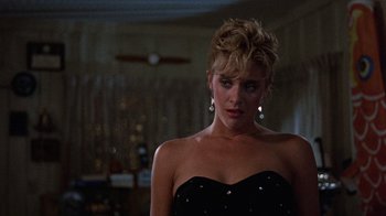 Movie still from “Innerspace” (1987), directed by Joe Dante – A woman in a strapless black dress with white polka dots; Close Up shot, Over the shoulder angle