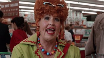 Movie still from “Innerspace” (1987), directed by Joe Dante – An older woman wearing a red wig and a green shirt; Close Up shot, Low angle