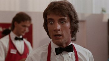 Movie still from “Innerspace” (1987), directed by Joe Dante – A man in a white shirt and a black bow tie; Close Up shot, Low angle