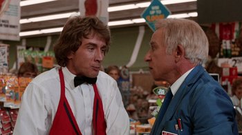 Movie still from “Innerspace” (1987), directed by Joe Dante – A man and a woman talking in a grocery store; Medium shot, Over the shoulder angle