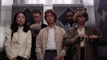 Movie still from “Innerspace” (1987), directed by Joe Dante – A group of people standing next to each other in a room; Medium shot, Low angle