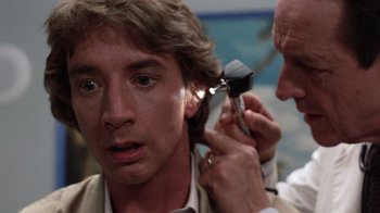 Movie still from “Innerspace” (1987), directed by Joe Dante – A man is getting his ear examined by a doctor; Close Up shot, Over the shoulder angle