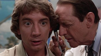 Movie still from “Innerspace” (1987), directed by Joe Dante – A man is looking at another man's ear; Close Up shot, Over the shoulder angle