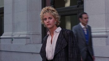Movie still from “Innerspace” (1987), directed by Joe Dante – A woman with blonde hair wearing a suit and tie; Medium shot, Low angle