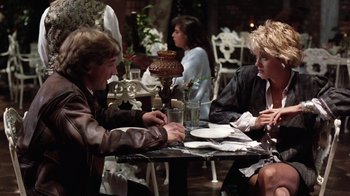 Movie still from “Innerspace” (1987), directed by Joe Dante – A man and a woman sitting at a table; Medium shot, Over the shoulder angle