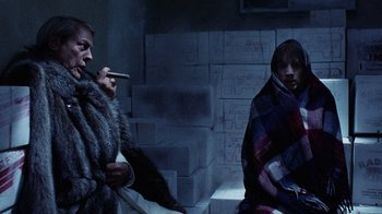 Movie still from “Innerspace” (1987), directed by Joe Dante – Two people sitting in a dark room with blankets; Medium shot, Low angle