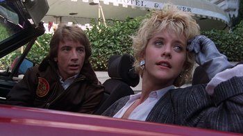 Movie still from “Innerspace” (1987), directed by Joe Dante – A man and a woman sitting in the back of a car; Close Up shot, Low angle