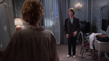 Movie still from “Innerspace” (1987), directed by Joe Dante – A man standing in front of another man in front of a window; Wide shot, Over the shoulder angle