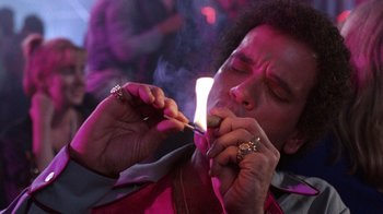 Movie still from “Innerspace” (1987), directed by Joe Dante – A man lighting a cigarette on a stick; Close Up shot, Low angle