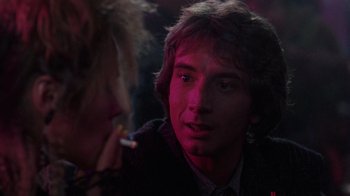 Movie still from “Innerspace” (1987), directed by Joe Dante – A young man smoking a cigarette in front of a woman; Close Up shot, Over the shoulder angle