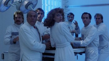 Movie still from “Innerspace” (1987), directed by Joe Dante – A group of people standing in a room; Medium shot, Low angle