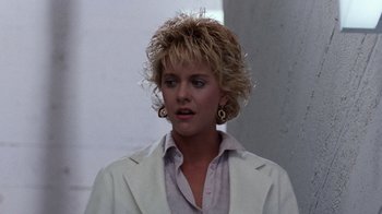 Movie still from “Innerspace” (1987), directed by Joe Dante – A woman in a white jacket and a pair of gold earrings; Close Up shot, Low angle