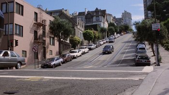 Movie still from “Innerspace” (1987), directed by Joe Dante – Cars parked on the side of the road on a sunny day; Extreme Wide shot, High angle