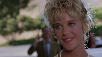 Movie still from “Innerspace” (1987), directed by Joe Dante – A woman's face with a man in the background; Close Up shot, Over the shoulder angle