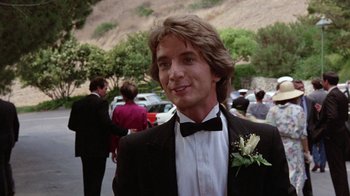 Movie still from “Innerspace” (1987), directed by Joe Dante – A man in a suit and bow tie standing in front of a crowd of onlookers; Close Up shot, Low angle