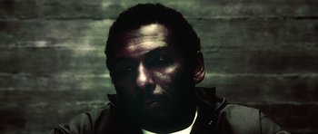 Movie still from “Inside Man” (2006), directed by Spike Lee – A person wearing a white shirt; Close Up shot, Low angle