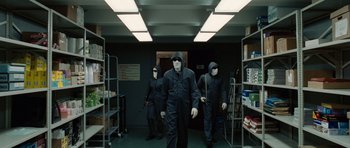 Movie still from “Inside Man” (2006), directed by Spike Lee – A group of people in black suits and masks; Wide shot, Low angle